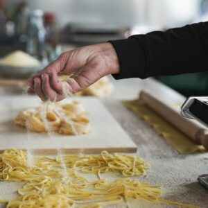 Woman working inside pasta factory - Fresh made taditional italian pasta